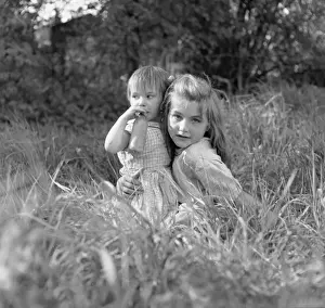 Hugging Prints: Two gipsy girls in a field, one with a feeding bottle
