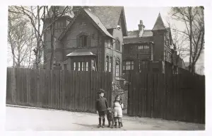 Girl and boy with dog outside their house