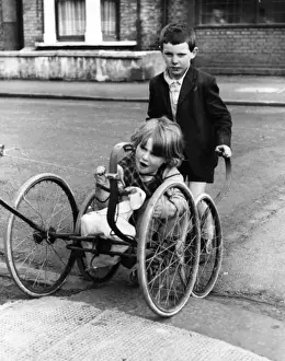 Girl and boy with pram wheels, Balham, SW London