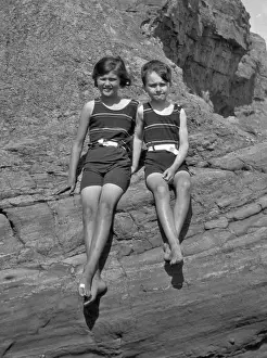 Swimsuits Prints: Girl and boy sitting on rocks at the seaside