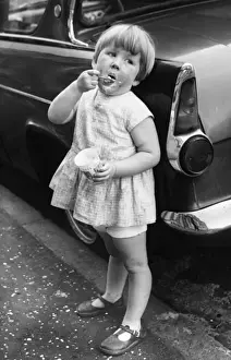 Girl eating ice cream on a Balham street, SW London