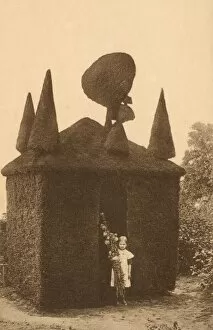 Along Side Collection: Girl stood by intricate topiary house