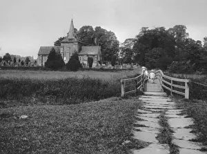 Girl and toddler on a bridge near a church