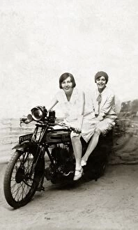 Girls on a 1922 Triumph SD motorcycle in studio