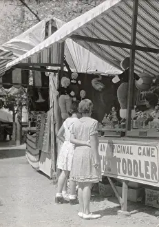 Fairground Prints: Girls looking at a stall at Looe fair, Cornwall Date: 1930s