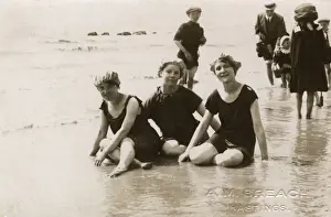 Swimsuits Prints: Three girls sitting in the surf at Hastings, Kent