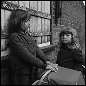 Images Dated 6th October 2015: Girls with toy pram in the street