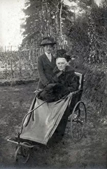 A rather grand-looking elderly lady going out for a spin in her bath chair along with her