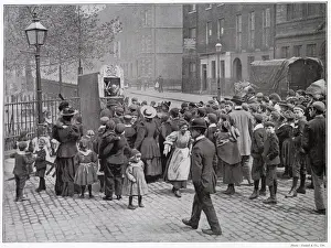 Judy Prints: A group of amused London children gather round to watch a traditional Punch and Judy