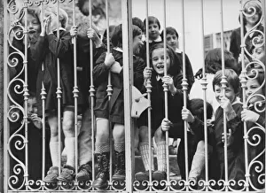 Group of children looking through school gates