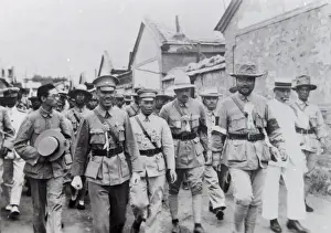 Group of dignitaries walking along a street, Far East