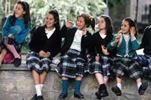 A group of happy schoolgirls wearing Spanish tartan skirts