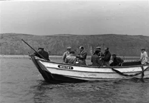 Group of men in a fishing boat with film camera