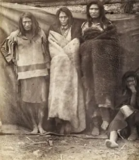 Group of Native Americans, three standing, one seated on