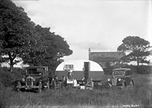 A group of five people having tea outside a caravan