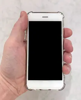 Clear Prints: A hand holding a modern white touch-screen mobile smartphone with a clear case. Date: 2022