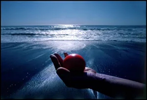 Hand holding red ball Moonstone Beach California