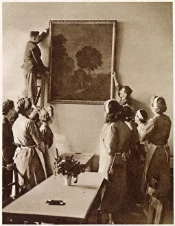 Images Dated 19th May 2021: Hanging a painting of a romantic landscape in the new Churchill British Restaurant in