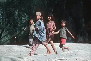 Curious Gallery: Four happy Kashmir children run along banks of River Jhelum
