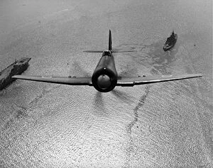 Flies Collection: Hawker Sea Fury X flies over an aircraft carrier and ship