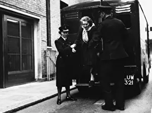 Stepping Prints: Helping woman out of the back of a police van, London