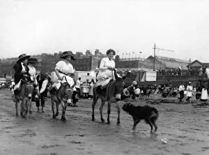 Sidesaddle Collection: Holidaymakers riding donkeys on a beach