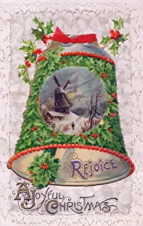 Holly with bell and snow scene on a Christmas postcard
