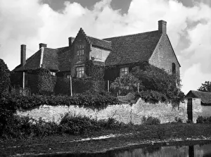 A house behind the remains of part of the walls of Wix Abbey, Essex, England