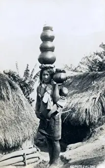 Igorote woman carring water pots and a baby