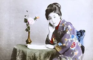 Japan - Geisha Girl - reading a book at a small table