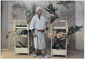 Holders Prints: A Japanese flower seller stands by a portable stall made of bamboo with integral holders