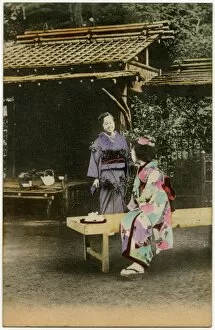 A Japanese Geisha girl taking tea in a garden