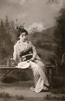 Courtesans Prints: A Japanese Geisha posing in a studio garden setting