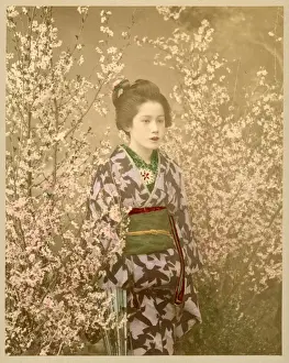 Japanese girl next to cherry blossom tree