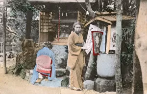 Japanese women pray at a wayside Shrine