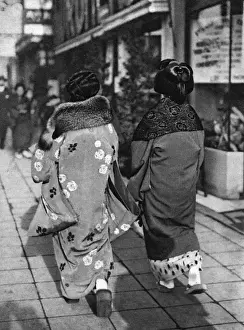 Two Japanese women walk down a street