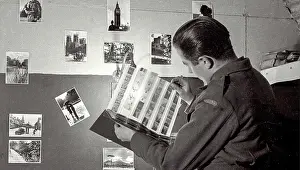 Examining Prints: John closely examining negatives in the darkroom where he was able to hone his skills as part of his time at the Polish