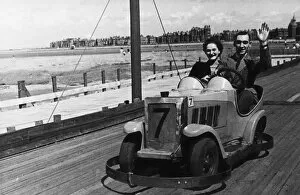 Jovial couple waving from a go-kart