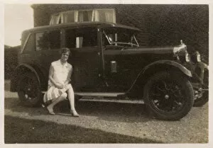 A lady ( Marion ) - sitting on the running board of her car