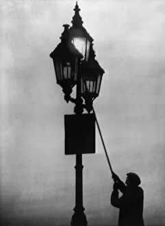 Lamplighter Gallery: A lamplighter at work in the London fog