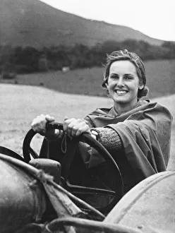 <b class=qtipBold><figcaption>Land Girls WWII</figcaption></b><br>Land Girl, Lin Gapp, a former secretary in a cosmetics laboratory, is protected by a ground sheet from rain as she drives a tractor on a farm during World War II<br><em>© Mary Evans/Robert Hunt Collectio</em> Land Girls WWII