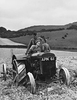 <b class=qtipBold><figcaption>Land Girls WWII</figcaption></b><br>Land Girl Vera Clarke learns how to drive a tractor with passengers Lin Gapp and an instructor during World War II. Vera was an orchestra leader in Lyons Corner House and Lin was a secretary in a cosmetics laboratory.<br><em>© Mary Evans/Robert Hunt Collectio</em> Land Girls WWII
