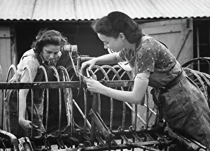 <b class=qtipBold><figcaption>Land Girls WWII</figcaption></b><br>Land Girls Christine Reed and Colette Boivin overhaul a hay rake that has been brought in from the fields for repairs. Christine was formerly a typist in the city and Colette was a London tailoress.<br><em>© Mary Evans/Robert Hunt Collectio</em> Land Girls WWII