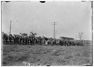 Large crowd of spectators gathered at the edge of a field at Large crowd of spectators gathered at the edge of a field at
