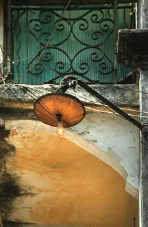Images Dated 8th August 2019: Light bulb glows during the day from a rickety street lamp