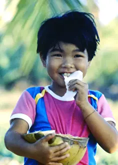 Thailand Prints: Little boy eating coconut, Thailand