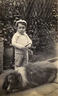 Paved Prints: Little boy with large dog in a garden