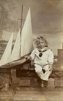Little boy in his sailor suit with his toy boat