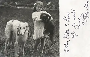 Little girl with a cat and a dog in a garden