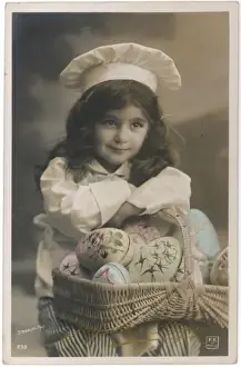Little girl in chefs costume with a basket of painted eggs